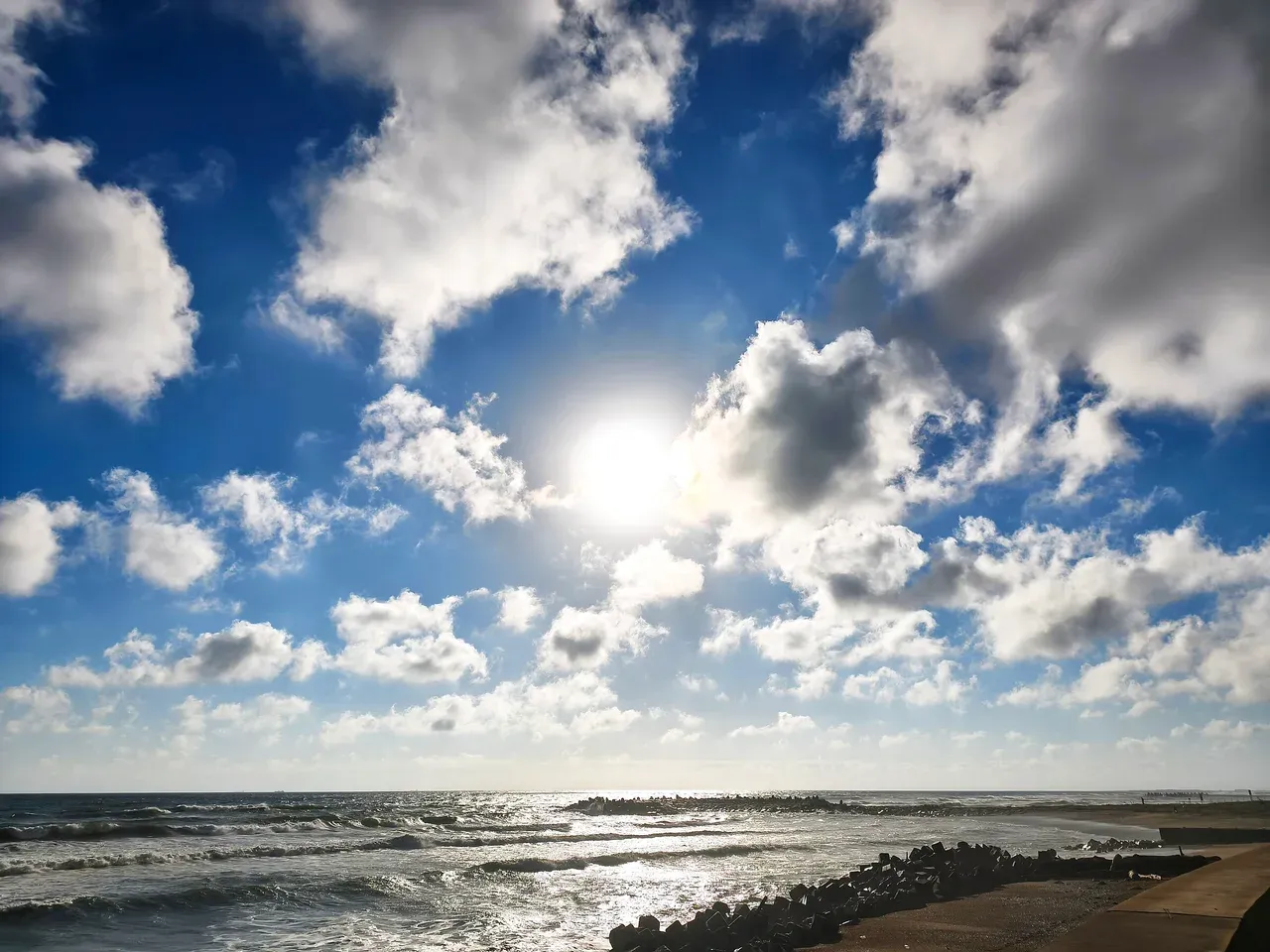 朝の海。雲のあいだから日が差している