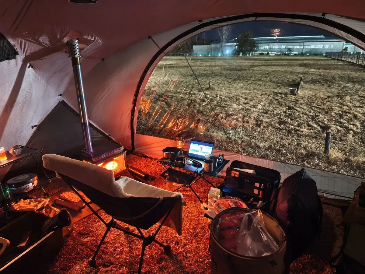薪ストーブで暖まる夜のテント内