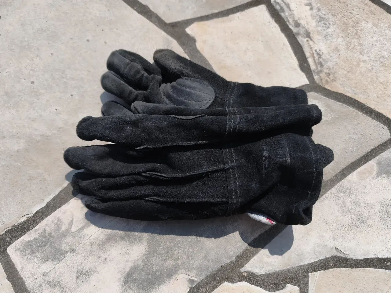 東和コーポレーション EXTRAGUARD TAKIBIグローブ。使い込んで馴染んだ黒い革手袋