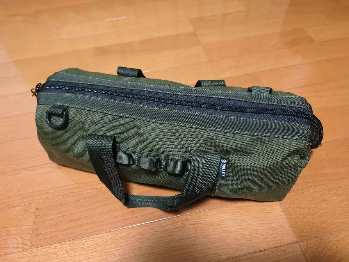 オリーブ色のペグケース（BULLET）に焚き火一式を収納した状態。閉じるとコンパクトなバッグになる