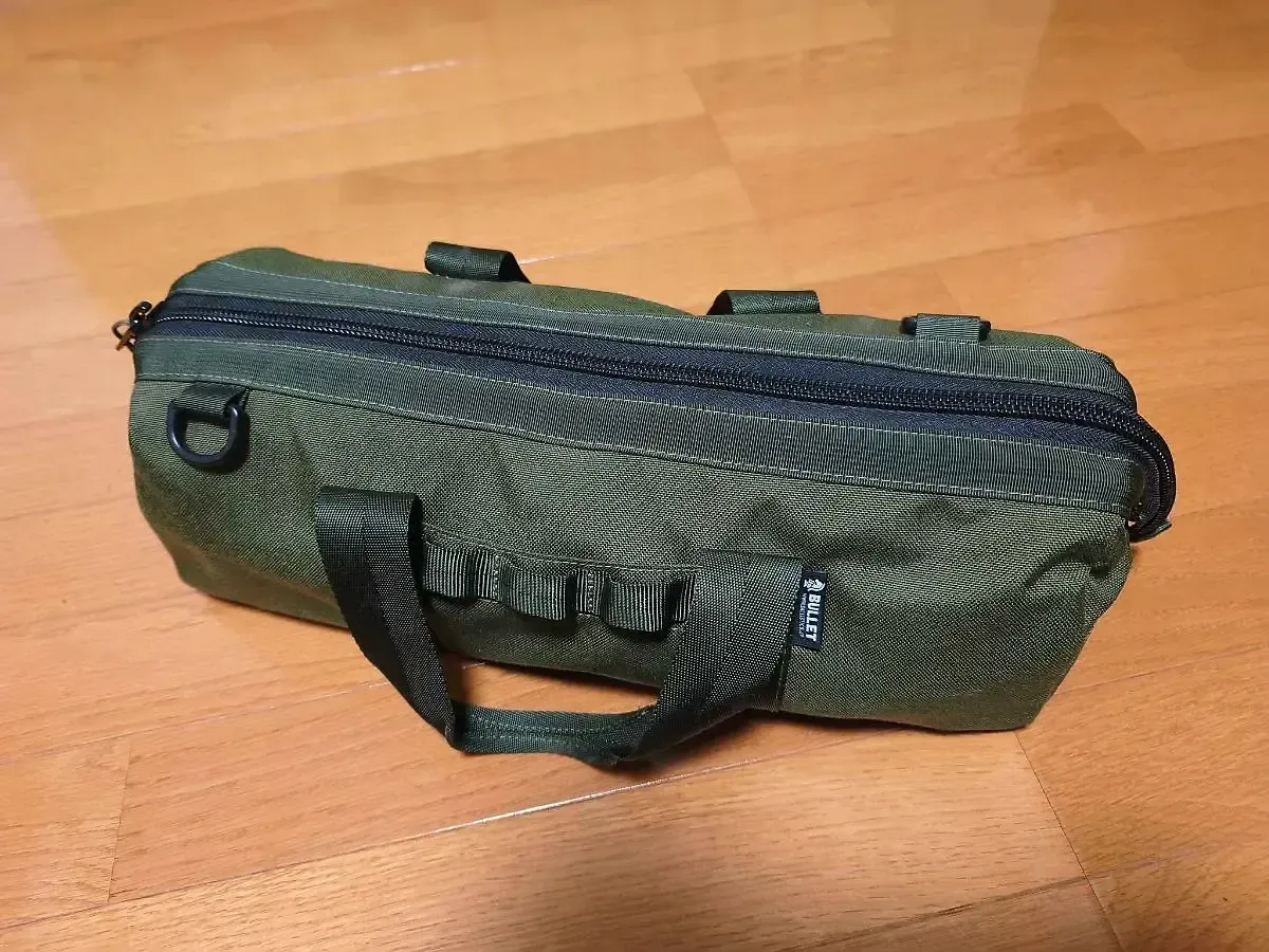 オリーブ色のペグケース(BULLET)に焚き火一式を収納した状態。閉じるとコンパクトなバッグになる