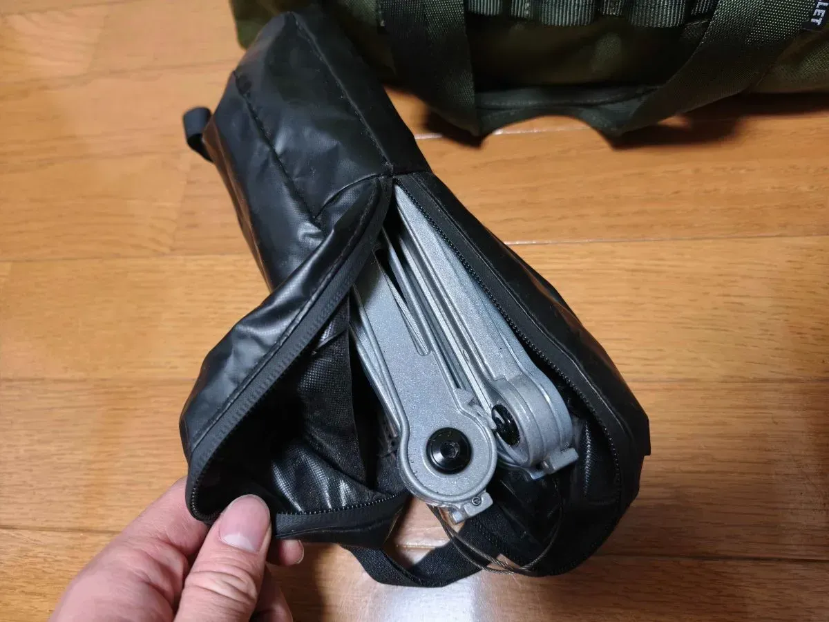 MONORAL WireFlame Solid MT-0110を収納袋から取り出したところ。折りたたまれたアルミフレームが手のひらに収まるサイズ感